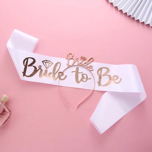 Braut-Set mit roségoldenem Stirnband und Bride to Be Satinschärpe auf rosa Hintergrund