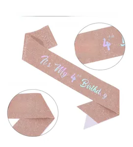 Detail of rose gold glitter sash with 4th birthday lettering and crown motif for girls