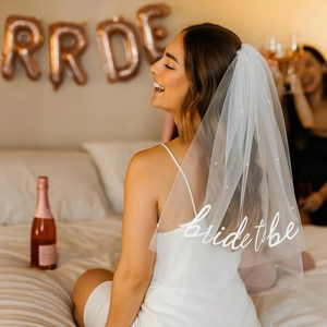 Detail of white single-layer bridal veil with pearls and Bride to Be script text