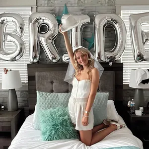 White bridal outfit with veil and cowboy hat featuring silver Bride text decoration