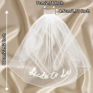 White bridal veil with pearls and bride to be text on champagne silk background