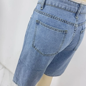 Detalle de los pantalones cortos de mezclilla azul claro con cintura alta y costuras amarillas