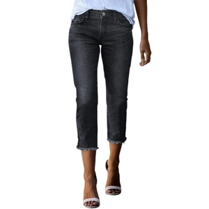 Detail view of slim fit dark gray cropped jeans featuring trendy frayed hem edges