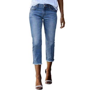 Detail showing frayed fringe hem on mid-blue washed cropped denim jeans for women