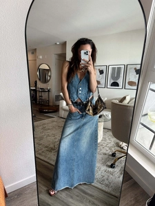 Détail du gilet en jean rétro et jupe longue à taille haute avec ourlet brut