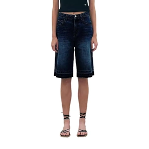 Detail of dark blue high-waisted denim Bermuda shorts with retro wash and heavy stitching