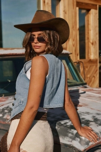 Vue extérieure d'un gilet en jean bleu clair avec jupe en dentelle blanche et chapeau
