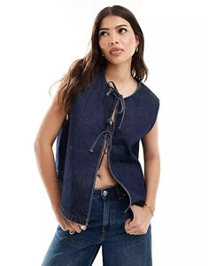 Detail of dark blue sleeveless denim vest with front lace-up ties and thick cotton fabric