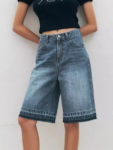 Women's vintage high-waisted denim Bermuda shorts in a dark wash with raw hem detailing