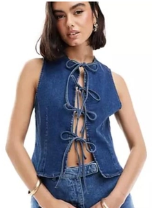 Detail of dark blue denim vest featuring four front bow tie closures and cut-out design