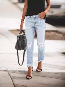 Light blue distressed denim jeans for women featuring knee cutouts and frayed raw hems