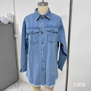Detail of light blue denim jacket featuring metallic buttons and raw hem fringe design