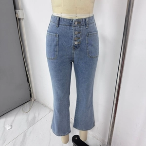 Detail of high waisted light blue flared jeans with four front buttons and large patch pockets
