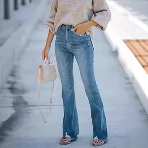 Close-up of high-waisted flared jeans in classic blue denim with frayed split hems