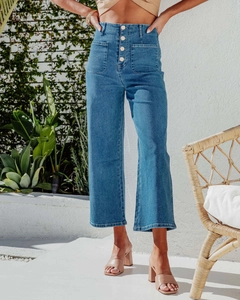 Detail of high waisted retro jeans featuring metallic buttons and large patch pockets