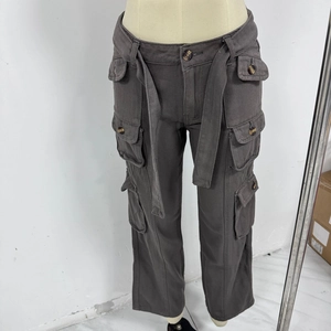 Detail shot of dark grey cargo pants featuring wide belt and multiple utility pockets