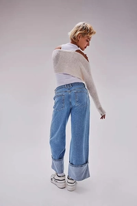 Detail of light wash wide-leg jeans with large cuffed hems and vintage-style faded finish