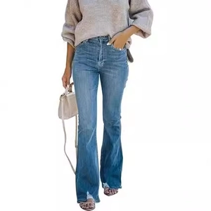 Detail of high waisted flare jeans in washed blue denim fabric with slim fit cut