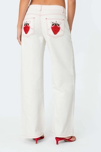 Detail of white wide-leg jeans with strawberry embroidery and pink bow on back pocket