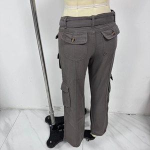 Detail of high waist grey cargo pants with flap pockets and durable twill fabric texture
