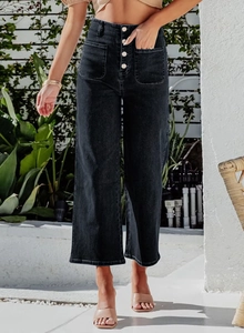 Detail of high-waist black wide-leg jeans with four-button fly and symmetric square pockets