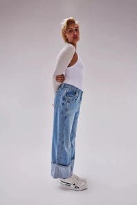 Detail view of light blue wide-leg jeans with oversized cuffed hems and vintage wash finish