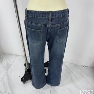 Detail view of deep blue washed denim jeans showing back pockets and stitching details