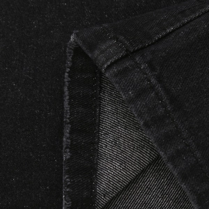 Detail view of black denim fabric texture and double-stitch hemming craftsmanship