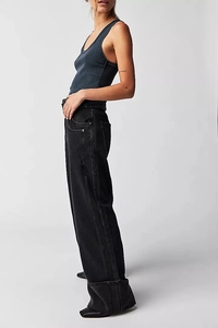 Detail view of high-waist wide-leg jeans with cuffed hems and white contrast stitching