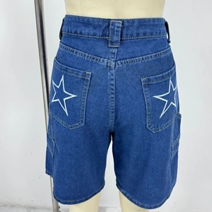 Dettaglio di pantaloncini in denim blu scuro con ricamo a stella bianca sulle tasche