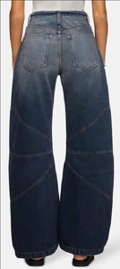 Détail d'un jean taille haute à jambe large avec empiècements en spirale et délavage vintage
