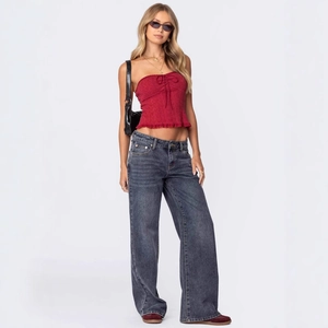 Close-up of a women's dark red tie-front tube top paired with baggy vintage blue jeans