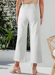 Back view of high waisted wide leg white denim trousers in a sunny summer outdoor setting