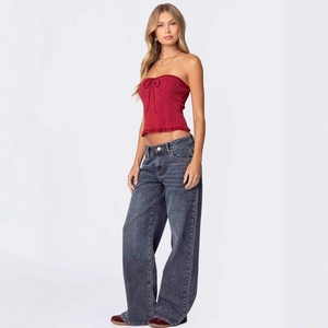 Full view of wide leg dark gray jeans with burgundy strapless bow top on model
