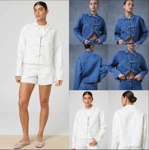 Détail d'une veste courte en jean avec rubans à nouer et col chemise élégant