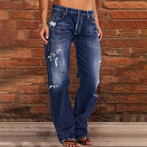 Detail of distressed dark blue jeans with heavy washing and natural knee rips