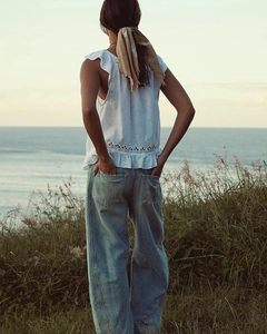 Détail du jean large bleu clair avec poches arrière au style côtier français