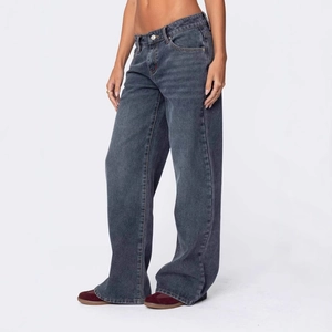Detailed close-up of dark grey wide-leg denim jeans with washed texture and relaxed fit