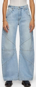 Détail de coutures en patchwork diagonal sur un jean bleu clair à jambes larges
