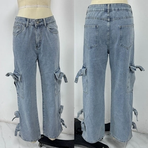 Detail of light blue denim cargo pants with side bow ties and utility pockets
