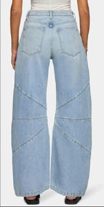Détails des coutures diagonales et poches arrière sur ce jean bleu clair délavé