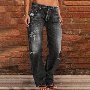 Close-up of distressed grey denim jeans featuring vintage wash and knee rip details