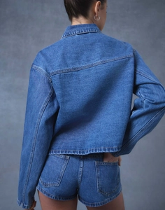 Vue arrière d'un ensemble veste en jean délavé bleu ample et short assorti femme