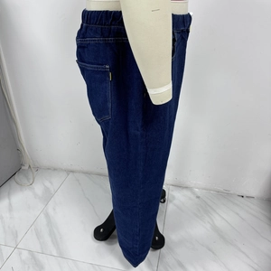 Detail view of deep blue denim jeans showing elastic waist and durable stitching details