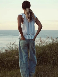 Jean bleu clair vintage à jambe large avec haut blanc en dentelle pour un look d'été