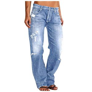 Detail of light blue distressed jeans showing knee rips and frayed tassel hemline