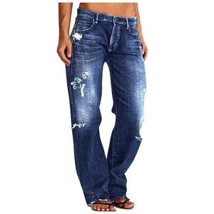 Detail shot of vintage distressed dark blue straight jeans with ripped knees and frayed edges