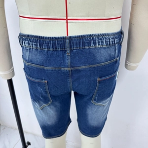 Detail view of denim shorts with elastic waistband and back pockets in dark blue