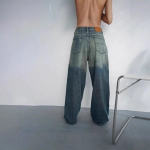 Detail of vintage low-rise wide-leg jeans with gradient wash and back leather patch