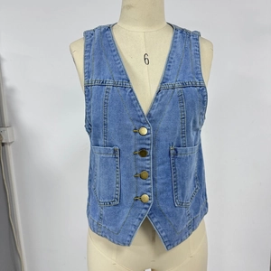 Detalle del chaleco vaquero azul con botones de metal vintage y bolsillos de parche simétricos